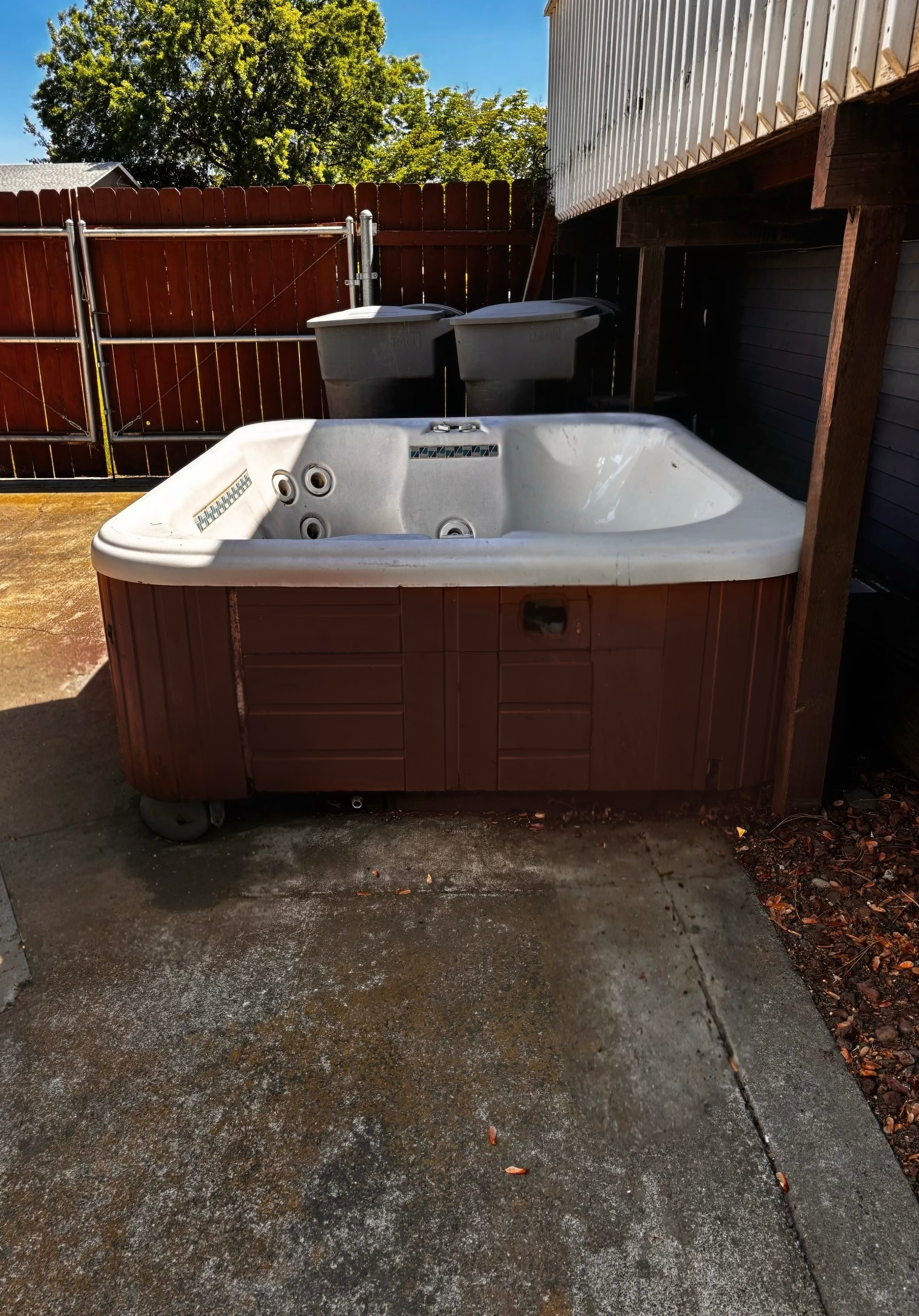 Cluttered hot tub before junk removal with debris, trash, and other junk