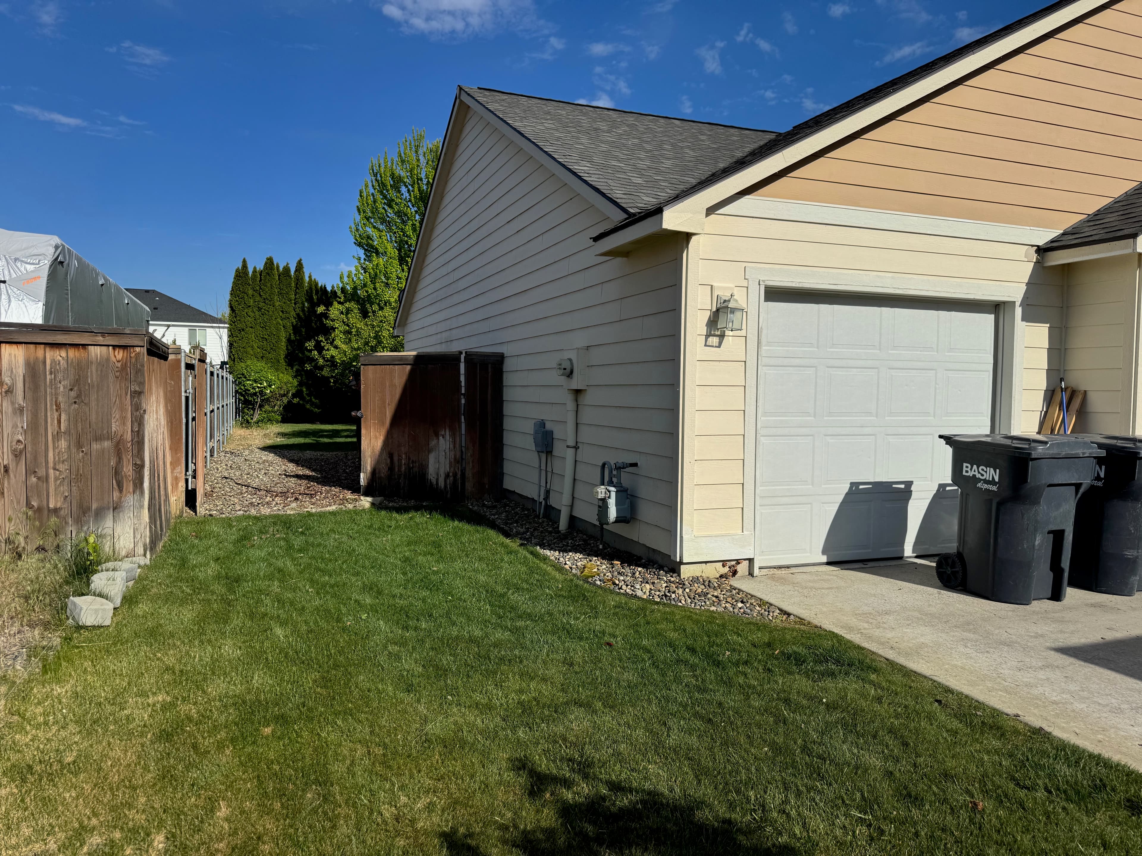 Clean yard and side area after junk removal with garage and fence visible