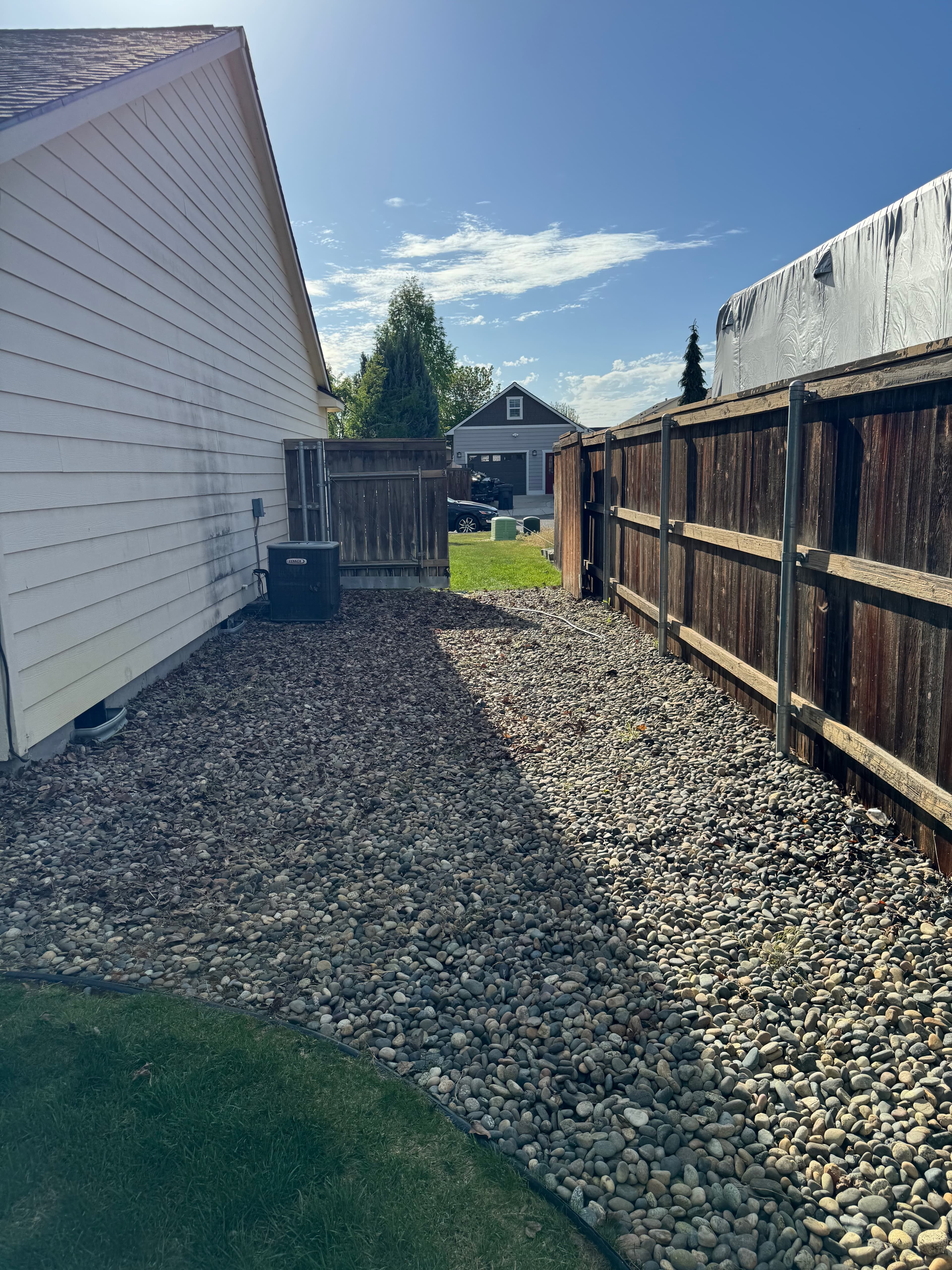 Cleared outdoor space after junk removal with garage and fence visible