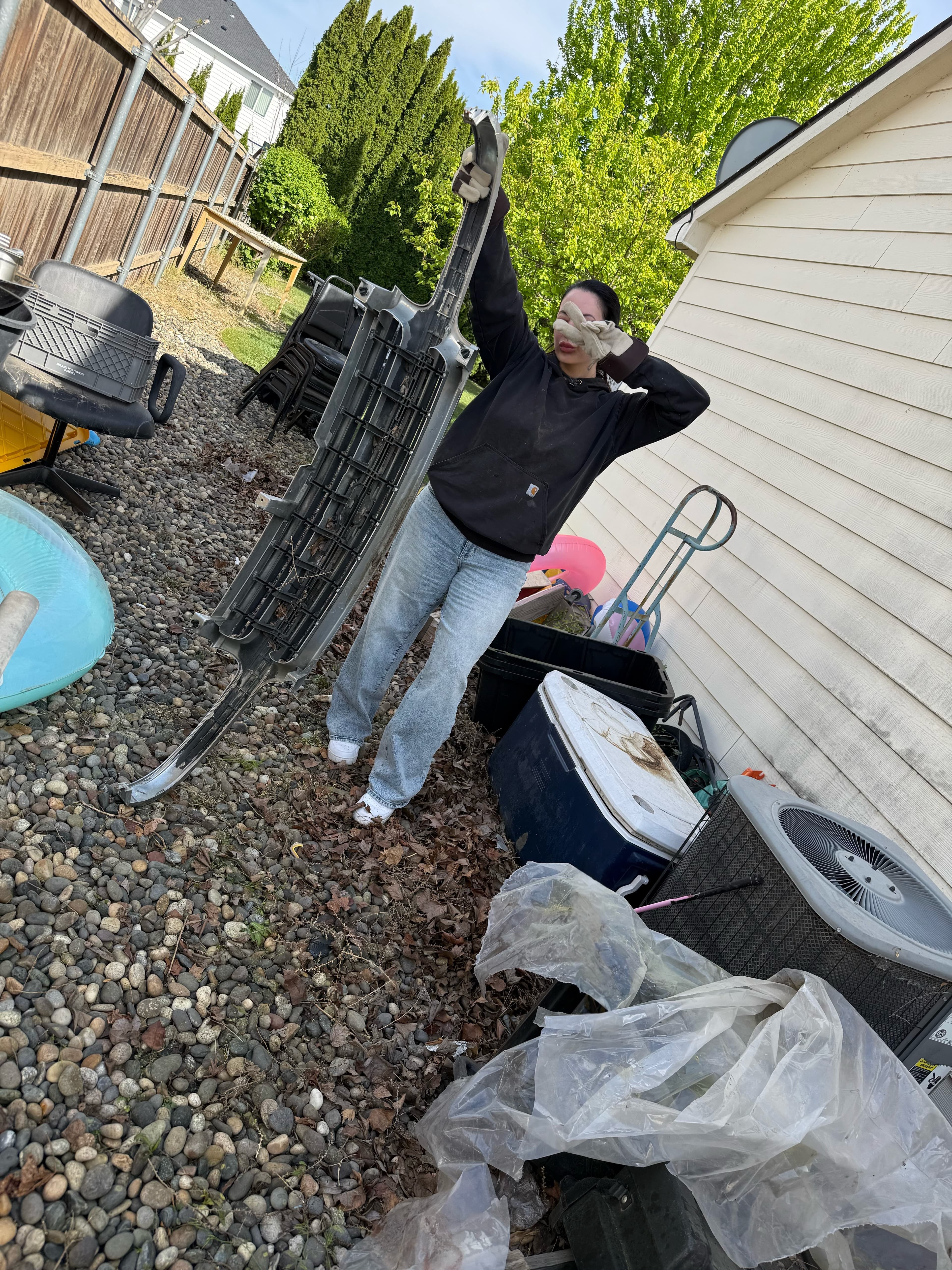 Higher Hauling crew member removing a bulky outdoor item from a side yard