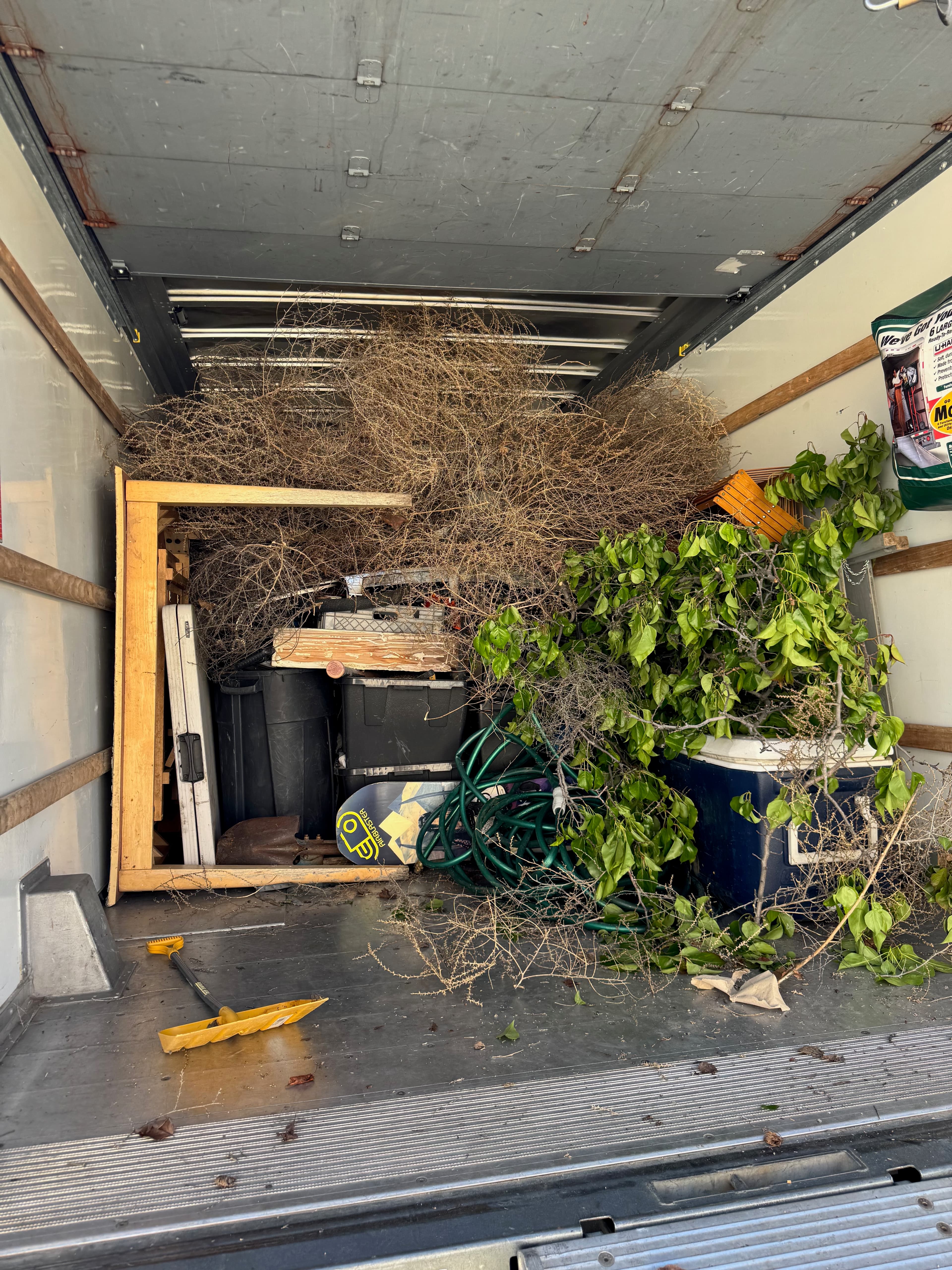 Loaded truck with ramp showing outdoor junk and yard debris ready for haul-away